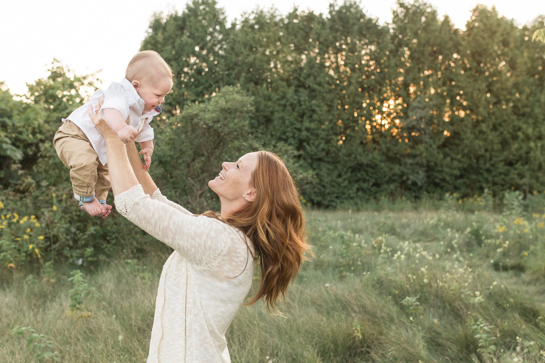 Mother lifting sun at sunset Family Photographer Guelph family blowing bubbles www.yellowbrickroadphoto.ca
