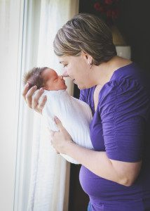 mother and newborn son by window