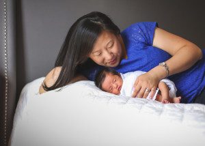 mother and newborn baby girl on bed