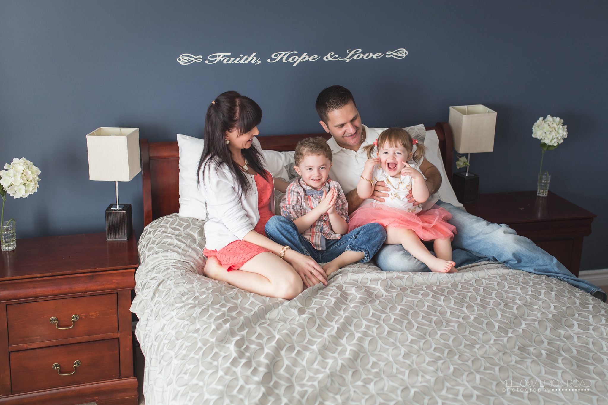 family sitting on bed pose