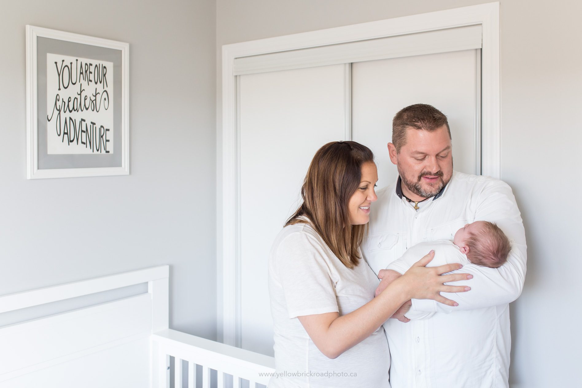 Breslau newborn lifestyle coupple holding new baby in nursery