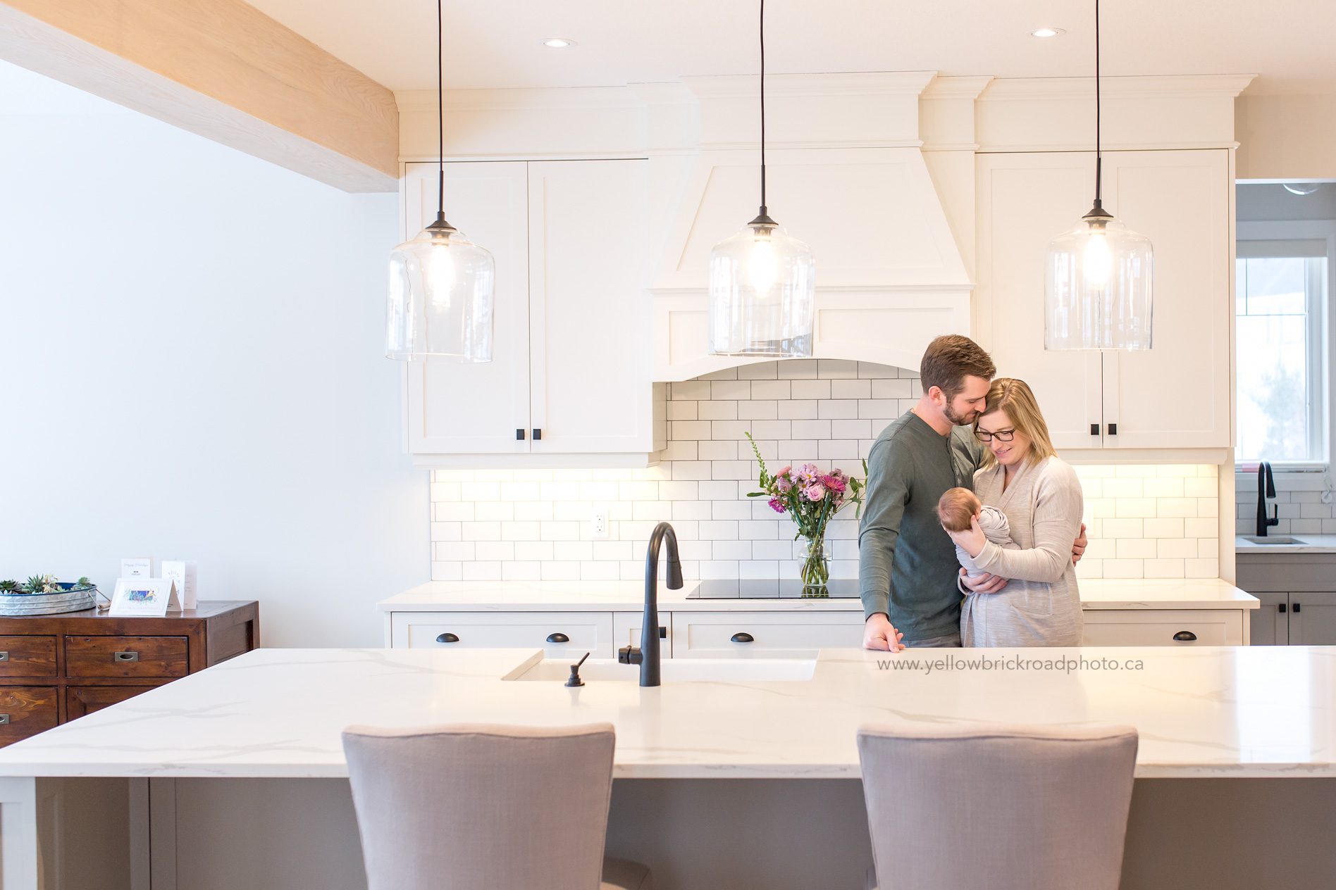 Newborn Lifestyle Photographer Guelph Parents holding baby in white kitchen