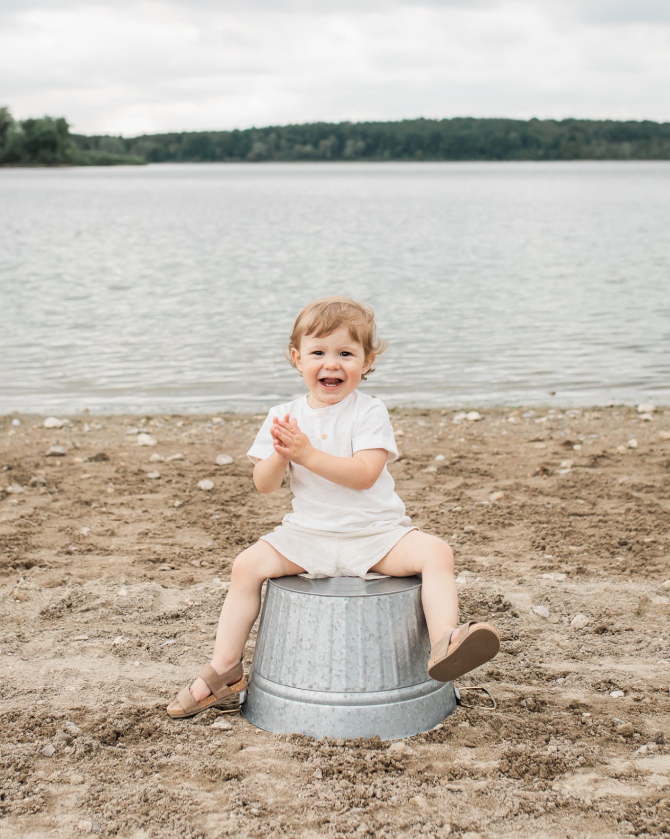 little boy on bucket at beach in guelph 